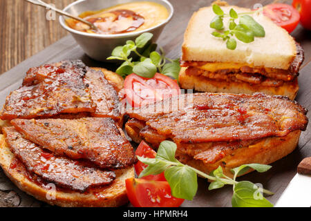 Sandwich mit gebratenem Speck auf hölzernen Hintergrund Stockfoto