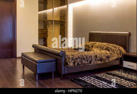 Moderne Schlafzimmer Innenraum mit Beleuchtung und ein stilvolles Bett vor einer weißen Wand in ein luxuriöses Zuhause.