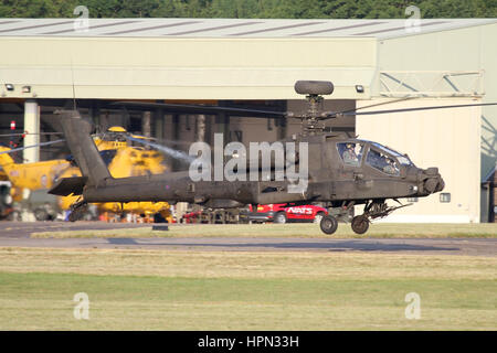 AAC-Apache Landung auf der Piste Wattisham während Schaltung üben. Die stillgelegte Such- und Rettungsaktionen Hangar kann hinter zu sehen. Stockfoto