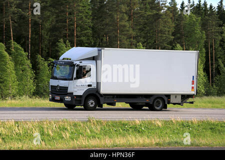 PAIMIO, Finnland - 3. Juni 2016: Weiße Mercedes-Benz Atego Lieferwagen transportiert Güter entlang der Autobahn an einem Sommerabend. Stockfoto