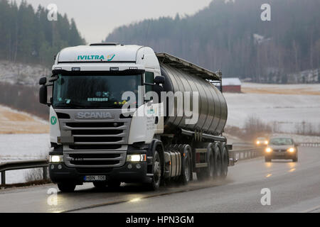 SALO, Finnland - 16. Dezember 2016: Sattelschlepper Tank weiß Scania R440 von Iviltra transportiert Güter auf nassem Asphaltweg an einem nebligen Tag im Winter. Stockfoto