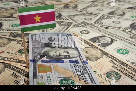 Flagge von Suriname in einer Vielzahl von amerikanischen Banknoten zu stecken. (Serie) Stockfoto
