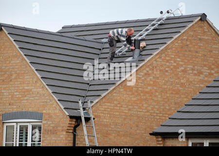 Arbeiter auf Hausdach, die Installation eines Kamins. Stockfoto