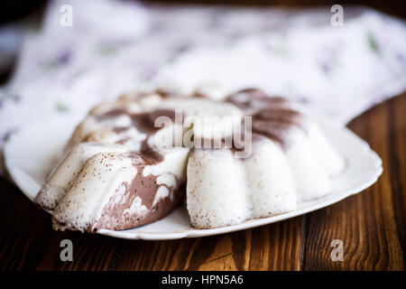 süße Milchschokolade Pannacotta auf schwarzem Hintergrund Stockfoto