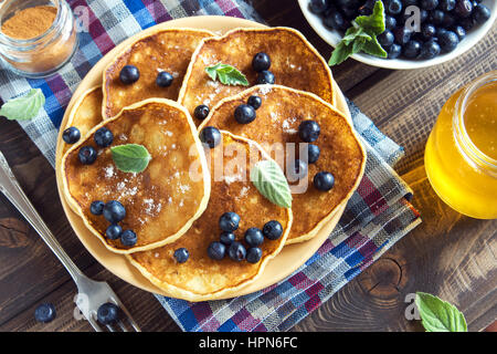 Pfannkuchen auf Teller mit Heidelbeeren, Walnüssen und Honig für gesundes Frühstück - hausgemachte vegetarische Ernährung Stockfoto