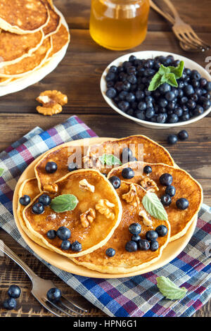 Pfannkuchen auf Teller mit Heidelbeeren, Walnüssen und Honig für gesundes Frühstück - hausgemachte vegetarische Ernährung Stockfoto