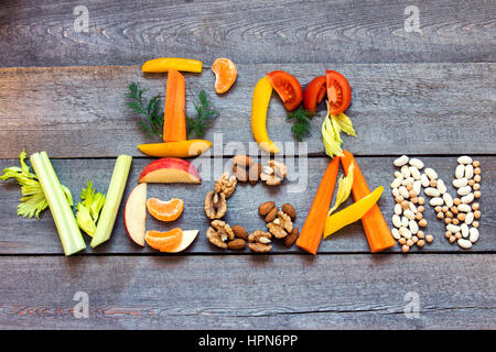 Worte "Ich bin Veganer" geschrieben mit Gemüse, Früchten, Nüssen und Hülsenfrüchten auf rustikalen hölzernen Hintergrund, Konzept - Bio-Zutaten für gesunde vegane Lebensmittel Stockfoto