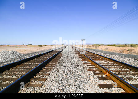 Eisenbahn in der Sonoran Wüste, Arizona, USA, mit Oberleitung Kabel auf der einen Seite und den alten uns Highway 80 zum anderen verfolgt und ein Berg klingelte Stockfoto