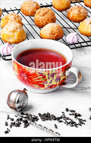 Hausgemachten Profiteroles Eclairs Dessert mit Tasse Tee Stockfoto