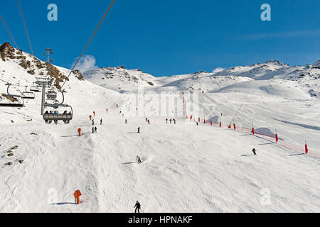 Skifahrer auf einer Skipiste piste im Winter Alpine Mountain Resort mit Sessellift Stockfoto