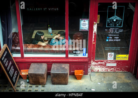 London, Vereinigtes Königreich - 5. April 2015. Kingsland Rd. paar im Chat bei einem Bier auf einem Chesterfield-Sofa. Stockfoto