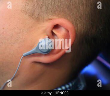 Nahaufnahme von grau Kopfhörer in mans Ohr Stockfoto