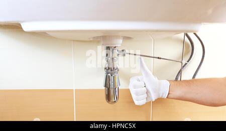 Hand mit Daumen oben auf Bad Hintergrund. Gute Sanitär Reparaturen. Stockfoto