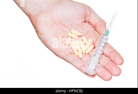 Pillen und Spritze auf der Seite isoliert auf weißem Hintergrund. Medizinische Instrumente und Medikamente. Stockfoto