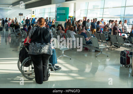 Übergewichtige Frau und Mann im Rollstuhl warten, um einen Ryanair Flug am Flughafen Dublin, Irland Stockfoto