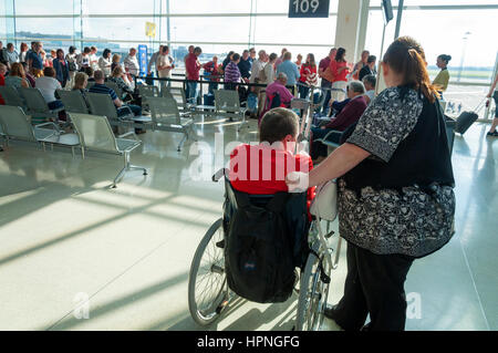 Übergewichtige Frau und Mann im Rollstuhl warten, um einen Ryanair Flug am Flughafen Dublin, Irland Stockfoto