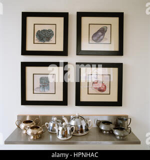 Kunst über ein Regal von antiken Teekannen hängen. Stockfoto
