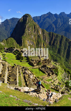Blick auf die verlorene Inka-Stadt Machu Picchu in der Nähe von Cusco, Peru. Machu Picchu ist eine peruanische historische Heiligtum. Im Vordergrund sind Menschen zu sehen. Stockfoto