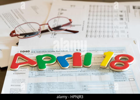 Holzbuchstaben auf 1040 Einkommensteuererklärung für 2016 zeigt Steuer-Tag für die Einreichung ist 18. April 2017 Stockfoto