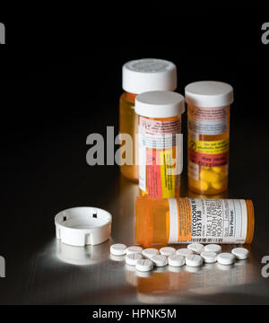 Oxycodon ist der Oberbegriff für eine Reihe von Opoid schmerzstillende Tabletten. Verschreibung Flasche für Oxycodon Tabletten und Pillen auf Metall-Tisch für opioid Stockfoto