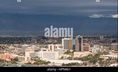 Innenstadt von Tucson in Arizona mit der Sonne, die Beleuchtung der Gebäude während Gewitterwolken über fernen Bergkette zu sammeln Stockfoto