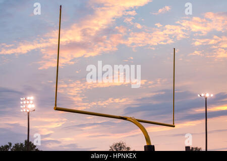 Gelb-american-Football Torpfosten an Schule Feld gegen die Lichter und die Wolken der untergehende Sonne Stockfoto