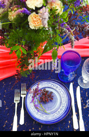 Tischdekoration im Vintage-Stil ist mit Blumen in rosa und blauen Farben dekoriert. Stockfoto