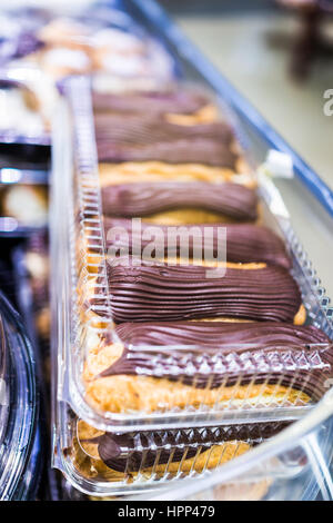 Viele große Schokolade Eclairs auf dem Display in Kunststoff-Box im store Stockfoto