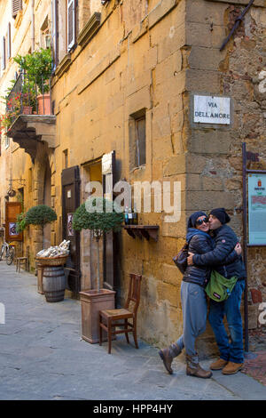 Paar küssen unterhalb Via Dell Amore Straße melden Sie sich an mittelalterliche Stadt Pienza, Toskana, Italien Stockfoto