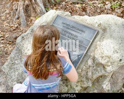 Junges Mädchen lesen Plaque, die Benennung des Teufels Millhopper als ein Naturdenkmal eingetragen. Geologische State Park. Gainesville, Florida, USA Stockfoto