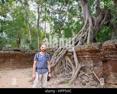 Mann stand vor einem riesigen Baumwurzel am Tempel Ruine Standort Angkor wat Stockfoto