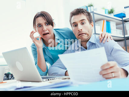 Junge Paar Rechnungen, Steuern und Bank Kontostand prüfen, sie sind in Panik, Schulden und Lebenshaltungskosten Konzept betont Stockfoto