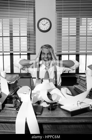 Verzweifelte Buchhalter schreien Kopf in Händen in Vintage 1950er-Jahre-Stil-Büro. Stockfoto