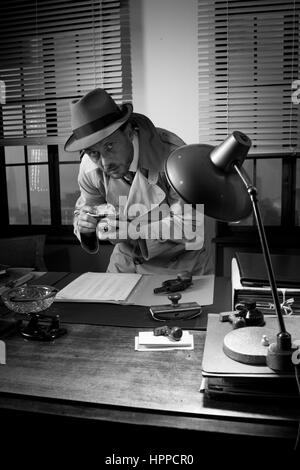 Retro-Spion Agenten gefangen wichtige Dokumente auf Schreibtisch, 1950er-Jahre-Stil zu fotografieren. Stockfoto