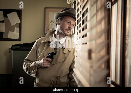 Attraktive Spion Agent spähen aus einem Büro-Fenster, Film Noir. Stockfoto