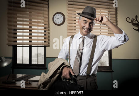 Lächelnde Geschäftsmann Ausscheiden aus dem Amt holding Aktenkoffer und Trenchcoat, 1950er-Jahre Stil. Stockfoto