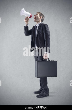 Ein junger Geschäftsmann schreien über Megaphon Stockfoto