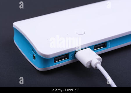 Portable Powerbank für mobile Geräte auf dunklem Hintergrund laden. Stockfoto