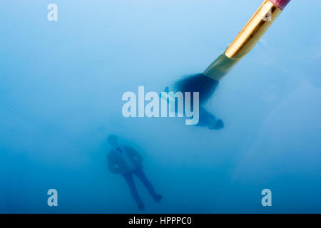 Malerei Pinsel und kleinen schwimmenden Figuren im Blauwasser Stockfoto