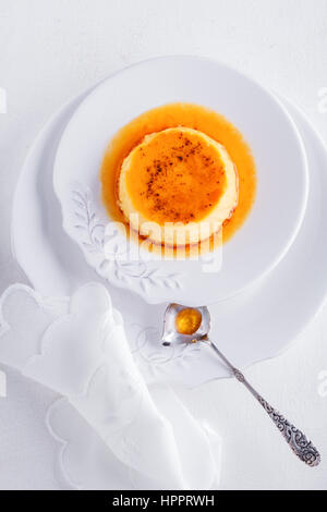 Creme Caramel auf einem Teller serviert auf einem Tisch Stockfoto