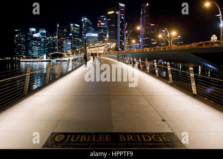 Scape Blick auf die Stadt mit der Jubilee Bridge-Foregroumd und dem Central Business District-Hintergrund in Marina Bay in der Nacht. Stockfoto