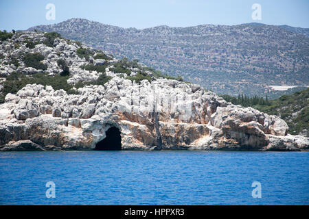 Meer in der Bucht von Uchagiz im Mittelmeer Türkei mit blauem Meer und Berge im Hintergrund unscharf Höhle Stockfoto