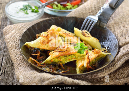 Fried schwäbischen Ravioli (so genannte "Maultaschen") mit Gemüse-Füllung serviert mit Beilagensalat und cremige Kräuterkäse Stockfoto