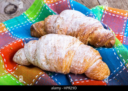 Croissants mit Puderzucker auf Hintergrund von alten Platten. Studio Photo Stockfoto