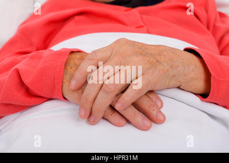 Ältere Frau ihre Hand im Bett Stockfoto