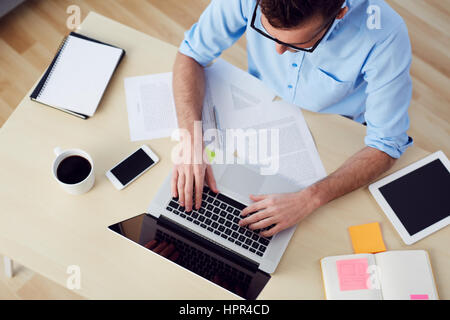 Draufsicht der Geschäftsmann Tippen auf Laptop am Schreibtisch - Mock-up Stockfoto