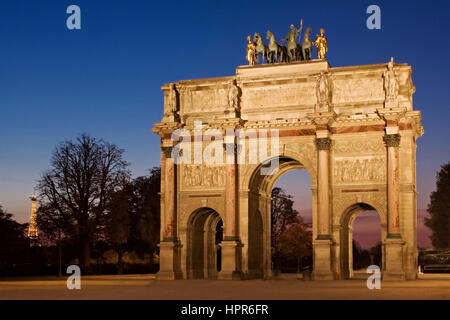 Nachtansicht des Arc de Triomphe du Carrousel in der Nähe des Louvre in Paris, Frankreich. Der Eiffelturm ist nur in der Ferne links ersichtlich. Stockfoto