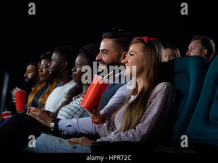 Bereit, einen neuen Film zu bewerten. Schuss von multikulturellen fröhlichen Freunden einen Film zusammen im örtlichen Kino Stockfoto