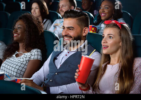 Unerwartete Wendungen. Closeup Aufnahme einer schönen jungen Frau suchen überrascht beim Ansehen eines Films im Kino mit ihren Freunden Stockfoto