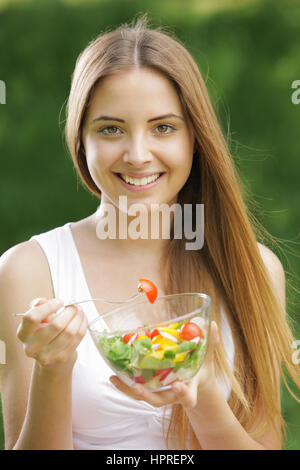 Porträt des jungen glücklich Frau essen Salat Stockfoto